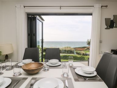 A dining room with a view of the sea at Praa Waves in Penzance
