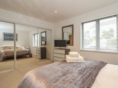A bedroom with a bed and a television at Praa Waves in Penzance