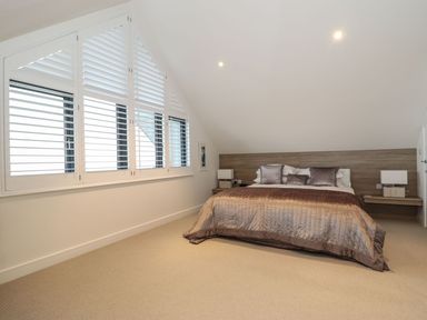 A bedroom with a bed and windows at Praa Waves in Penzance