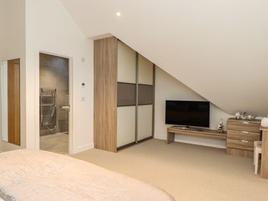 A bedroom with a television and a dresser at Praa Waves in Penzance