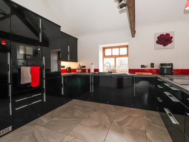 A kitchen with black cabinets and a window at Pillar Barn Driffield