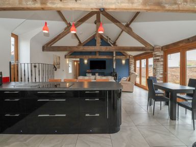 A kitchen with an island and dining area at Pillar Barn in Driffield