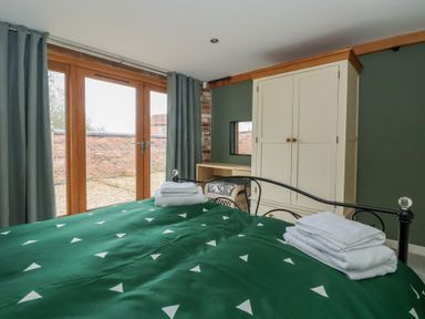 A bedroom with a bed and wardrobe at Pillar Barn Driffield
