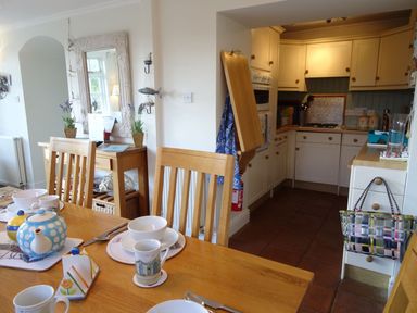 A dining room with a kitchen area and furniture at Mount Pleasant in Padstow