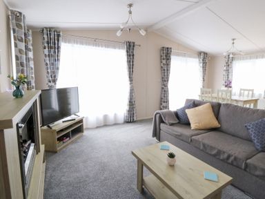A living room with a sofa and a television at Beechwood Lodge