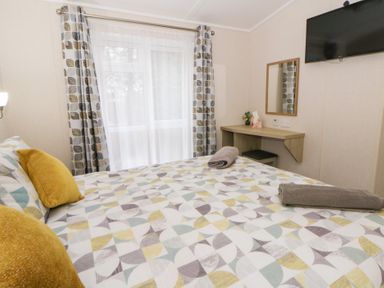 A bedroom with a bed and desk at Beechwood Lodge 
