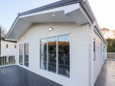 An exterior view of a house with windows and a deck at Beechwood Lodge