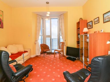 A living room with a sofa and two chairs at Val's Seaview in Ilfracombe