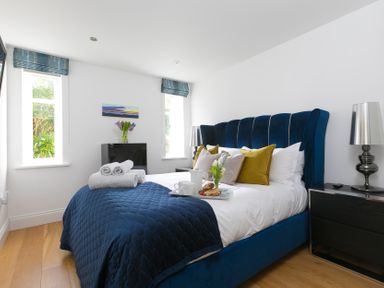 A bedroom with a bed and side table at 2 Remera in St Ives
