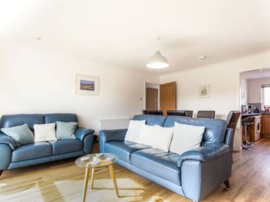 A living room with sofas and a table at Orchard View in St. Austell