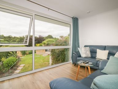 A sitting room with a sofa and coffee table at Orchard View in St. Austell
