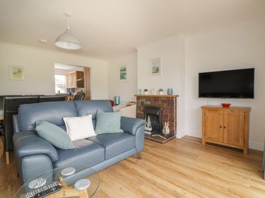 A living room with a sofa and television at Orchard View in St. Austell