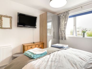A bedroom with a bed and a television at Orchard View in St. Austell