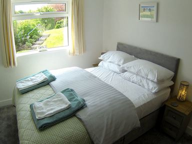 A bedroom with a bed and window at Orchard View in St. Austell