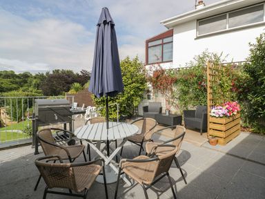 An outdoor seating area with a table and chairs at Orchard View in St. Austell