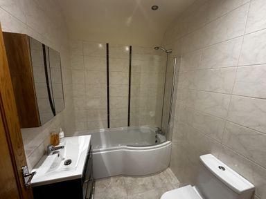 A bathroom with a bathtub, toilet, sink, and mirror at The Rocks in Newry