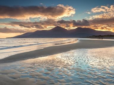 A beach with mountains and clouds at The Rocks in Newry