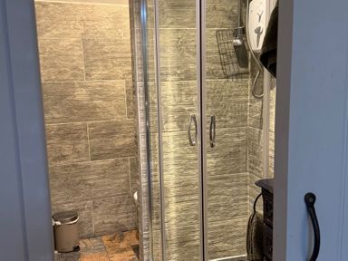 A shower area with glass doors at Studio Apartment at High Dyke Farm in Cockermouth