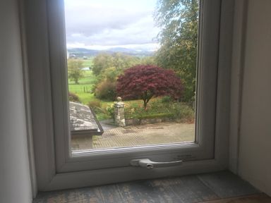 A view from a window showing a tree and garden at Studio Apartment at High Dyke Farm Cockermouth