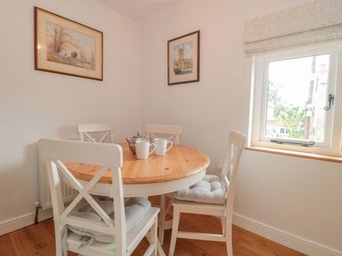 A dining room with a round table and chairs at Greenham Rise in Norton-Sub-Hamdon