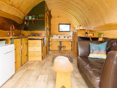 A living room with a kitchen area and a sofa at Glamping pod-Luxury Glamping Retreat in Battle