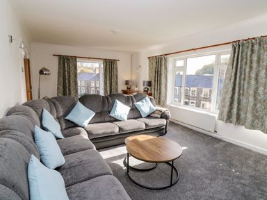 A living room with a sofa and coffee table at Tymelyn in Aberystwyth