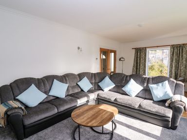 A living room with a sofa and coffee table at Tymelyn in Aberystwyth
