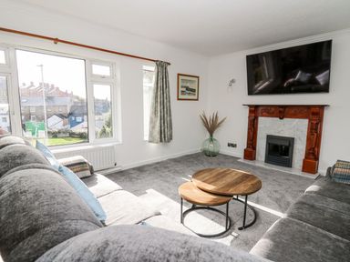 A living room with a sofa and a television at Tymelyn in Aberystwyth