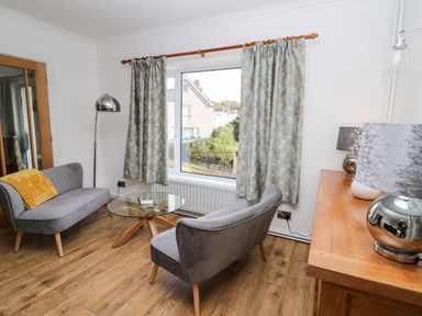 A living room with two armchairs and a coffee table at Tymelyn in Aberystwyth