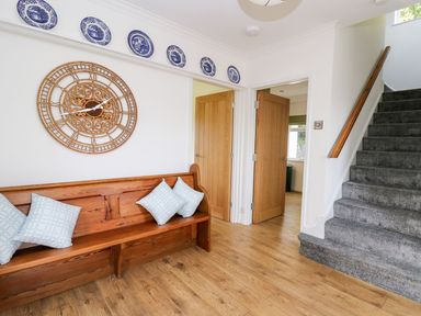 A hallway with a bench and clock at Tymelyn, Aberystwyth