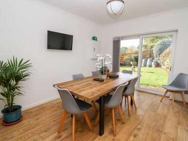 A dining room with a table and chairs at Tymelyn Aberystwyth
