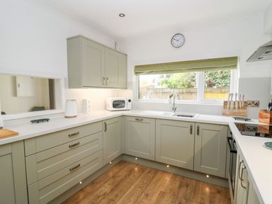 A kitchen with cabinets and a microwave at Tymelyn in Aberystwyth