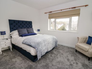 A bedroom with a bed and bedside table at Tymelyn in Aberystwyth
