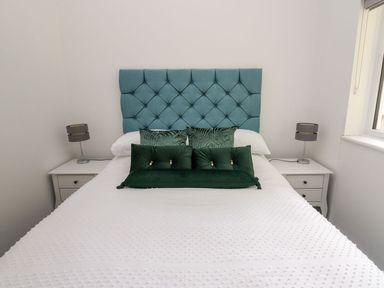 A bedroom with a bed and bedside tables at Tymelyn in Aberystwyth