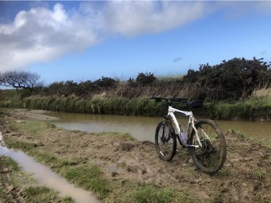 A mountain bike near a muddy path and water at Tylands in Camelford