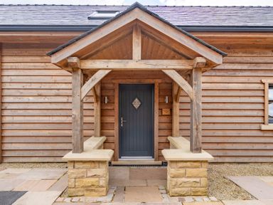 An entrance with a wooden gazebo and stone benches at Valley View Lodge 1 Preston