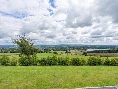 A view of green fields and a lake at Pendle View in Preston