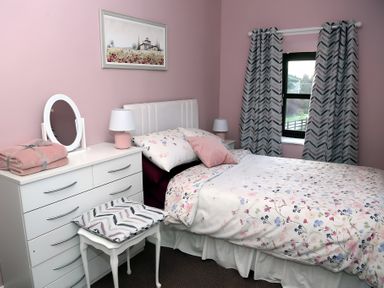 A bedroom with a bed and dresser at The Farmhouse in Omagh