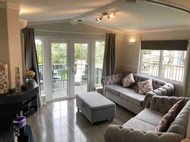 A living room with sofas and an ottoman at Caravan 38 in Newport
