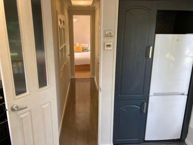 A kitchen with a refrigerator and hallway access at Caravan 38 Newport