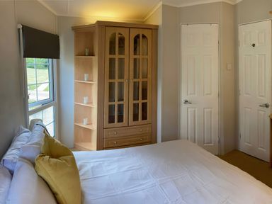 A bedroom with a bed and wardrobe at Caravan 38 Newport