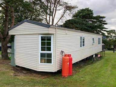 A caravan with gas cylinders and windows at Caravan 38 Newport