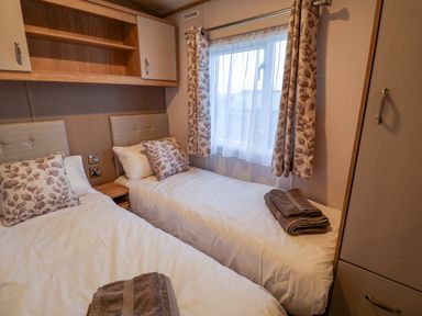 A bedroom with twin beds and a window at Paws By The Sea in Norwich
