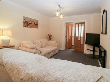 A living room with a sofa and lamp at Mables in Wigton