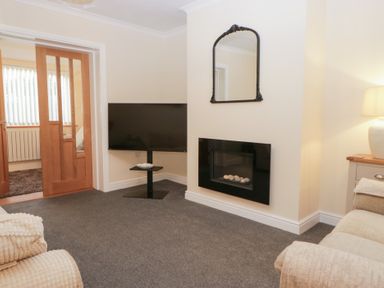 A living room with a television and fireplace at Mables in Wigton