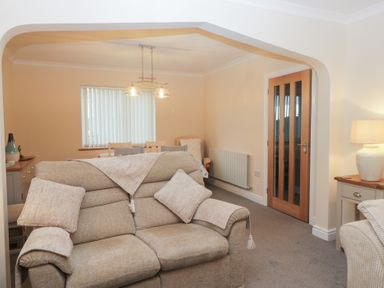 A living room with a sofa and table at Mables in Wigton