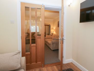 A living room with a doorway and sofa at Mables in Wigton