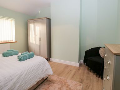 A bedroom with a bed and towels at Mables in Wigton