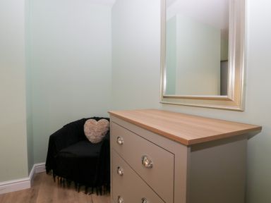 A dressing room with a mirror and chest of drawers at Mables in Wigton