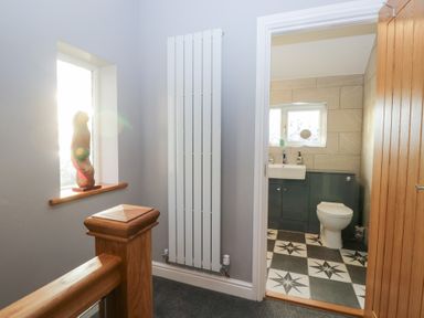 A hallway with a sculpture and a bathroom view at Mables in Wigton